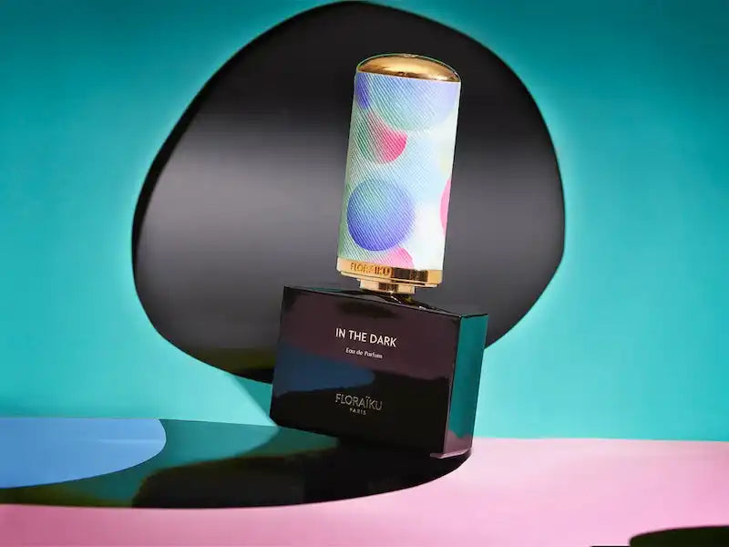 Cylindrical speaker with colorful dots pattern sitting on a black base.